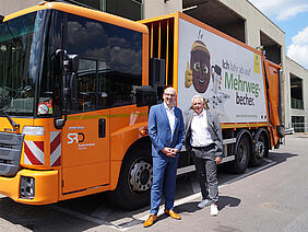 Herr Hammacher und Herr Schwaten vor orangem Müllauto